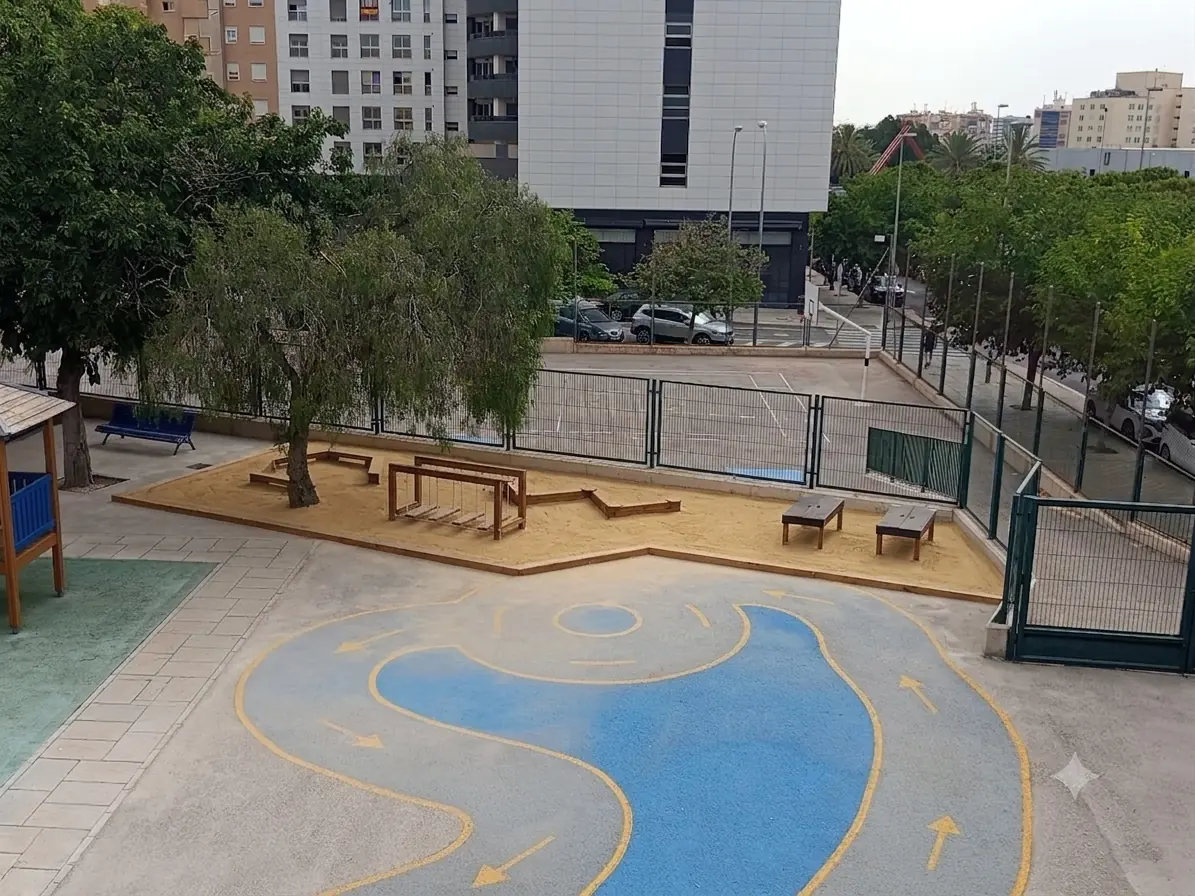 El mismo patio con zona de arena, ágora, areneros, zig-zag y puente tibetano de madera